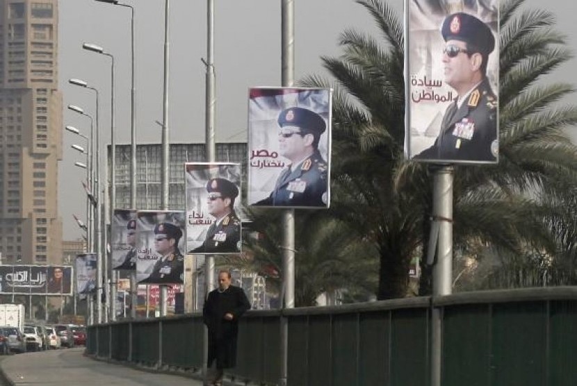 A man stands on a bridge where huge posters of Egypt's Army chief Field Marshal Abdel Fattah al-Sisi are hanged in central Cairo February 3, 2014.