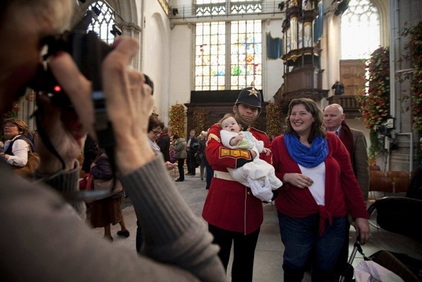 A man takes a picture of a guard holding a baby in the Nieuwe Kerk church the day after the investiture of King Willem-Alexander in Amsterdam May 1, 2013. Thousands of people took the opportunity to see the interior of the church which was used for the cer