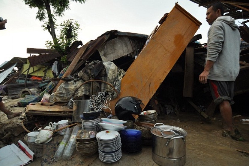 A man tries to save his belongis after his house hit by flash flood in Parigi Moutong, Central Sulawesi.  