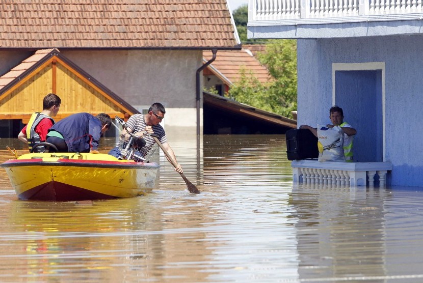 A man waits to be rescued from his house during heavy floods in Vojskova, May 19, 2014. 