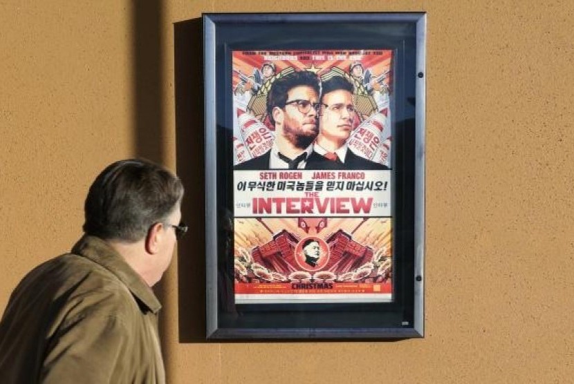 A man walks by the poster for the film ''The Interview'' outside the Alamo Drafthouse theater in Littleton, Colorado December 23, 2014.