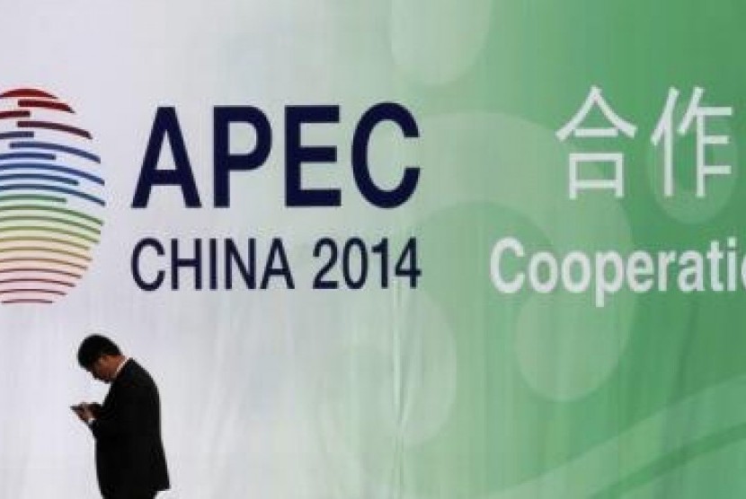 A man walks past a wall bearing a logo of the 2014 Asia Pacific Economic Cooperation (APEC) at the venue for APEC CEO Summit while its opening ceremony is being held in Beijing November 9, 2014. 