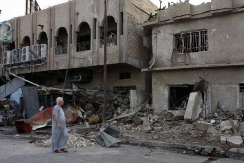 A man walks past the site of Wednesday's car bomb attack in Baghdad May 29, 2014. 