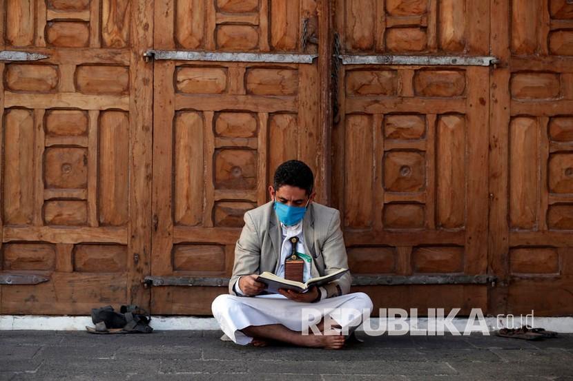  Seorang pria mengenakan masker membaca Alquran di sebuah masjid di Ibu Kota Sana’a, Yaman, Jumat (8/5). Otoritas Yaman melaporkan Aden, salah satu kota di negara itu, saat ini dalam kondisi infested atau penuh (tercemar) setelah jumlah kasus infeksi Covid-19 meningkat menjadi 35 pada Senin (11/5). Ilustrasi.