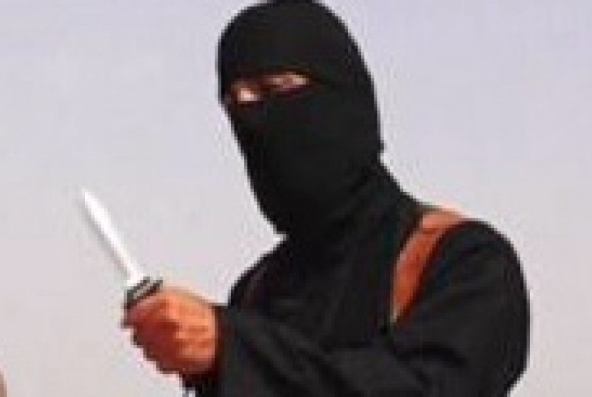 A masked Islamic State militant holding a knife speaks next to man purported to be US journalist James Foley at an unknown location in this still image from an undated video posted on a social media website.