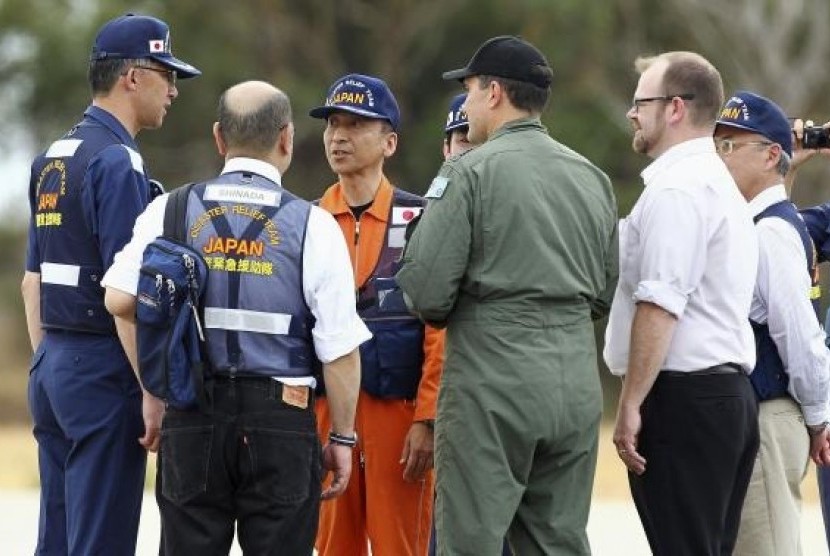 A member of the Japan Coast Guard (third left) is greeted by members of Japan's Disaster Relief Team and Australian officials, at RAAF Pearce airbase near Perth, March 26, 2014.