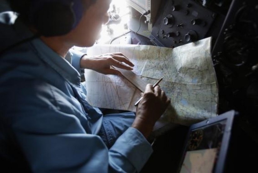 A military officer works on a map onboard a Vietnam Air Force AN-26 aircraft during a mission to find the missing Malaysia Airlines flight MH370, off Con Dao island, March 13, 2014.