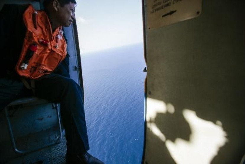 A military personnel looks out of a helicopter during a search and rescue mission off Vietnam's Tho Chu island March 10, 2014.