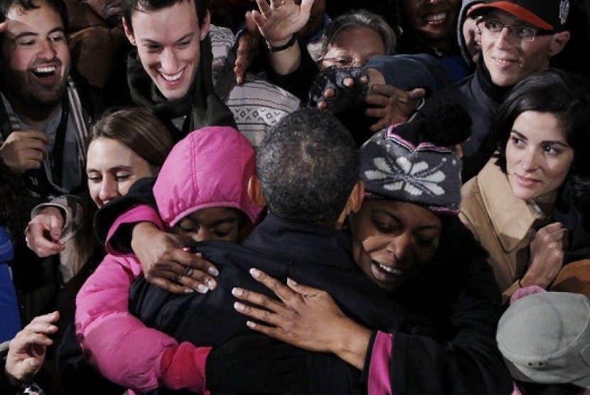 A mother and daughter hug U.S. President Barack Obama at the same time during a campaign rally in Bristow, Virginia, November 3, 2012.   