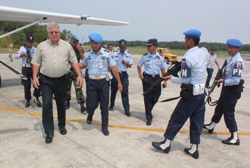 TNI Angkatan Udara mengawal pilot Cessna 208, Michael A Boyd (kiri) di Bandara Sepinggan, Balikpapan, Ahad (30/9) setelah ditangkap.
