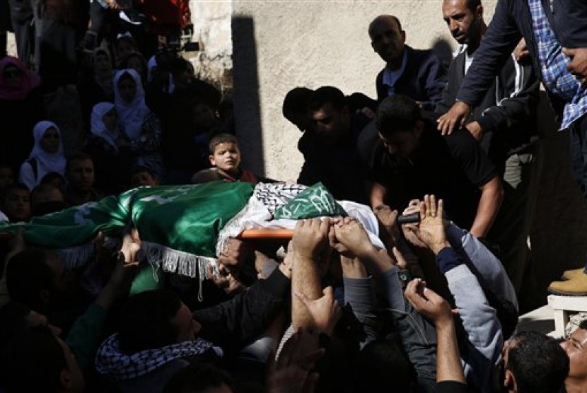 A Palestinian boy looks as mourners carry the body of 27-year-old Abdallah Shalaldeh, during his funeral in the West Bank village of Sa'ir, near Hebron, Thursday, Nov. 12, 2015