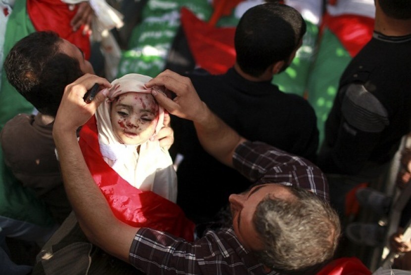 A Palestinian man adjusts the shroud covering the body of a child belonging to the al-Dalo family during his funeral in Gaza City November 19, 2012. Nine members of the al-Dalo family, including four children, were killed in an Israeli strike on their house on Sunday, Palestinian medics said.   