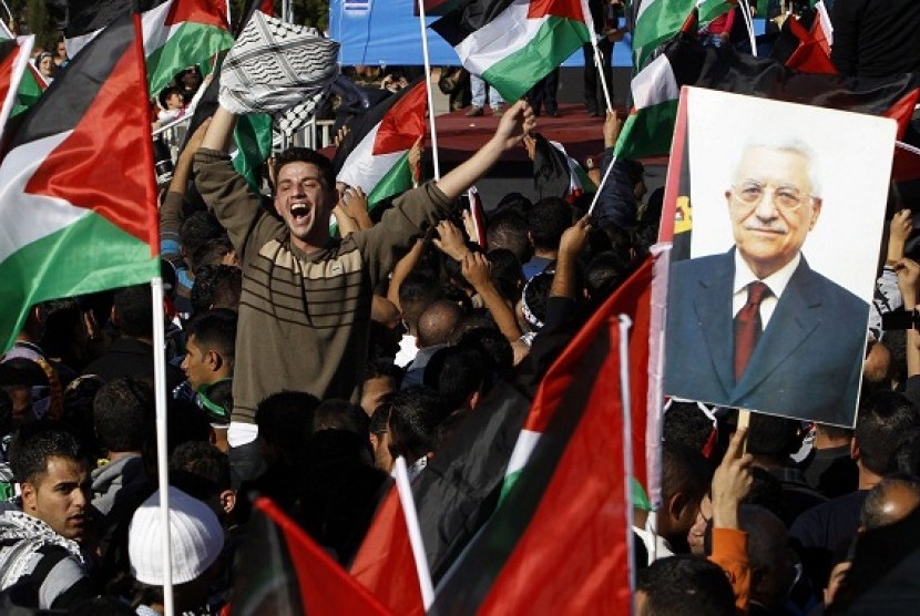 A Palestinian man cheers near a placard depicting President Mahmoud Abbas during a rally marking the U.N. General Assembly's upgrading of the Palestinians' status from 