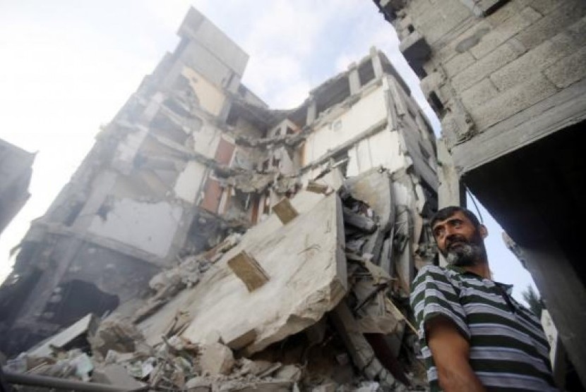 A Palestinian man stands near the remains of a charitable organization building, which witnesses said was hit by an Israeli air strike, in Khan Younis in the southern Gaza Strip August 25, 2014.