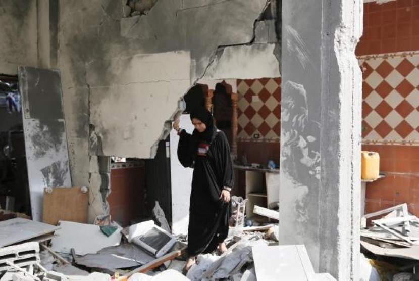 A Palestinian woman looks through her damaged home after returning to Beit Hanoun town, which witnesses said was heavily hit by Israeli shelling and air strikes during the Israeli offensive, in the northern Gaza Strip August 5, 2014.