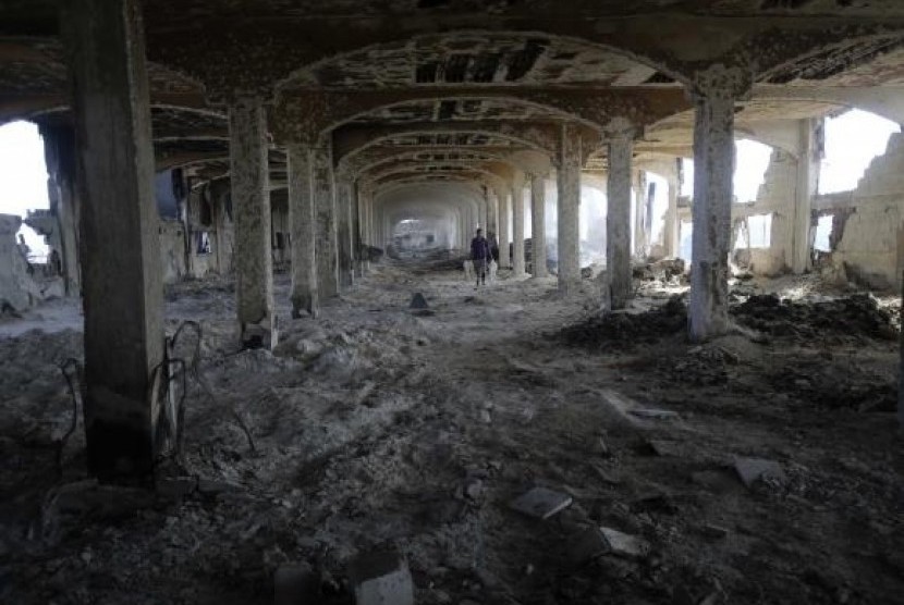 A Palestinian worker walks inside al-Awdah food factory, which witnesses said was shelled and torched by the Israeli army during the offensive, in Deirl al-Balah in the central Gaza Strip August 14, 2014.