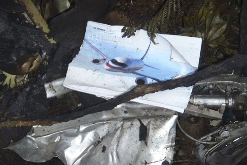 A picture of a Russian Sukhoi aircraft is seen between wreckage of this aircraft on the slope of Mount Salak, near Bogor.