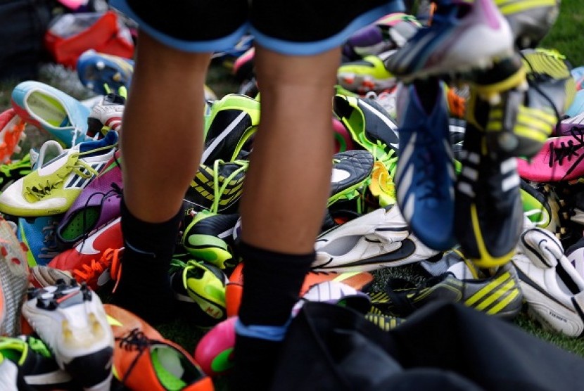 A player looks for his soccer shoes among a pile. (illustration) 