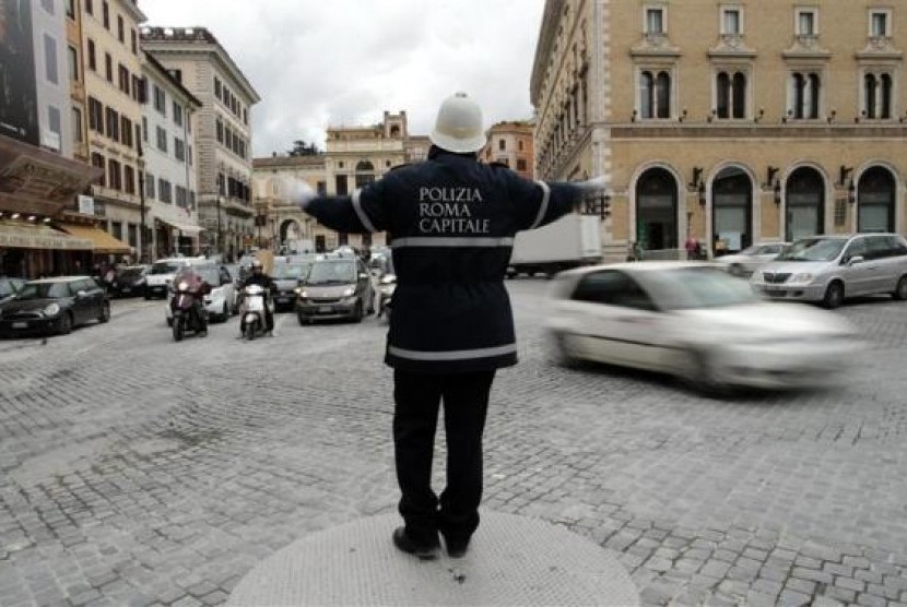 A policeman gestures as he directs traffic in downtown Rome January 24, 2014. 