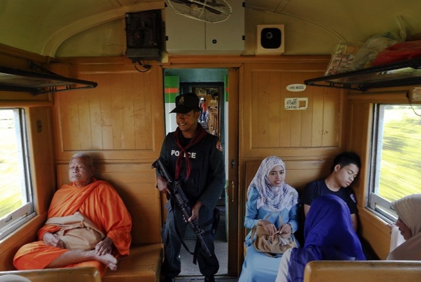 A policeman holds his weapon as he secures the train between provinces of Pattani and Yala, in Thailand's troubled deep south, in this March 9, 2013 file photo.