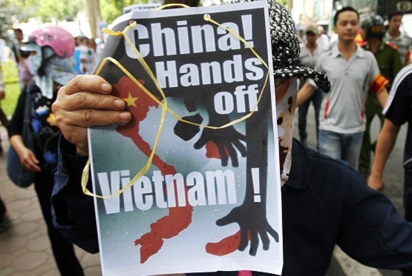 A protester holds an anti-China placard as she marches during a demonstration along a street in Hanoi July 8, 2012. Some hundred Vietnamese demonstrated in Hanoi on Sunday against China's moves to strengthen its claim on disputed islands in the South China