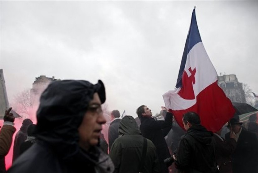 A protestor holds a French flag during a demonstration to criticize President Francois Hollande, in Paris, Sunday, Jan. 26, 2014. 