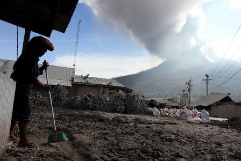 A resident cleans her house from Mount Sinabung's volcanic ash in Karo, North Sumatra, last week. (File photo)