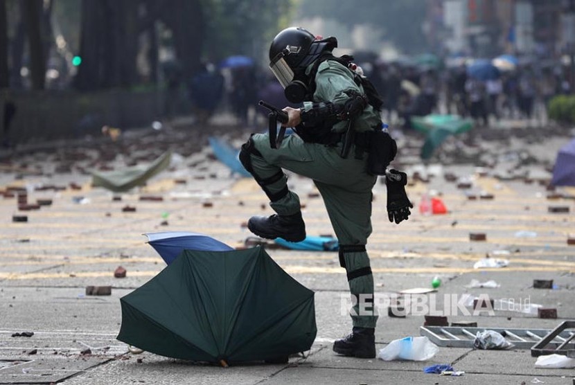 Polisi menginjak-injak payung di area kampus Hong Kong Polytechnic University. Polisi mengepung kampus dengan ratusan mahasiswa pengunjukrasa di dalamnya