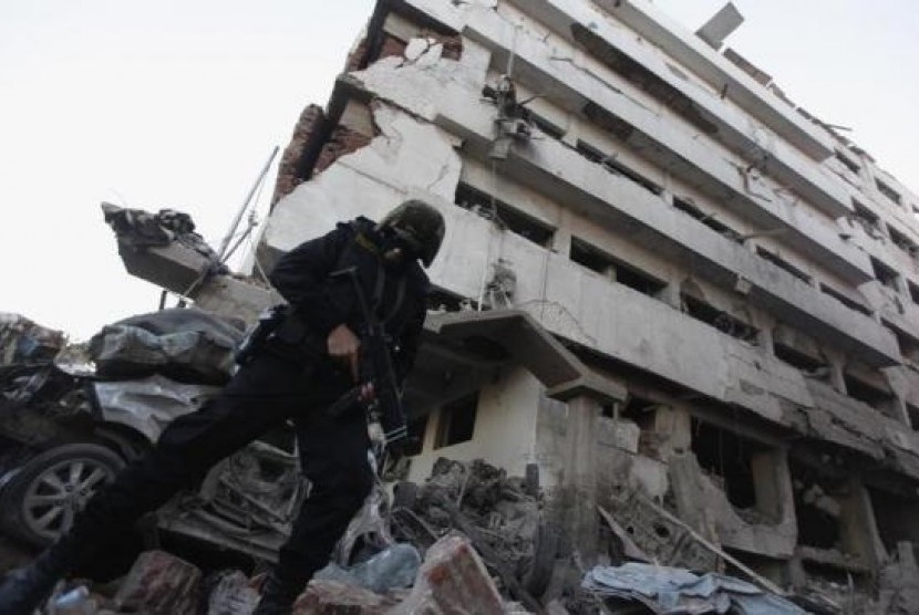 A riot policeman stands outside the building of the Directorate of Security after an explosion in Egypt's Nile Delta town of Dakahlyia, about 120 km (75 miles) northeast of Cairo December 24, 2013.