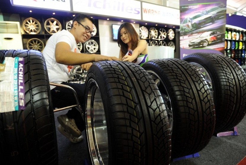 A salesperson helps a prospective buyer in a stand of PT Multistrada Arah Sarana during an exhibition in Jakarta. (illustration) 