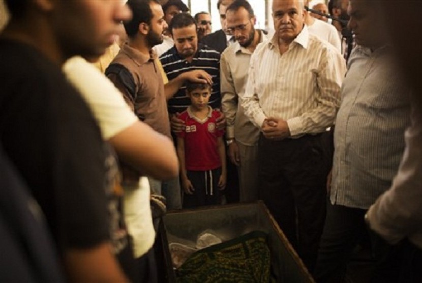 A son of Muslim Brotherhood's spiritual leader Mohammed Badie, prays while attending his burial in Cairo's Katameya district, Egypt, Sunday, Aug. 18, 2013. 