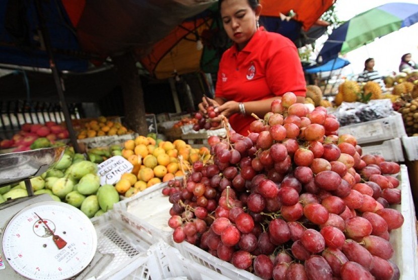 A street vendor arranges some imported fruit display in Jakarta. 