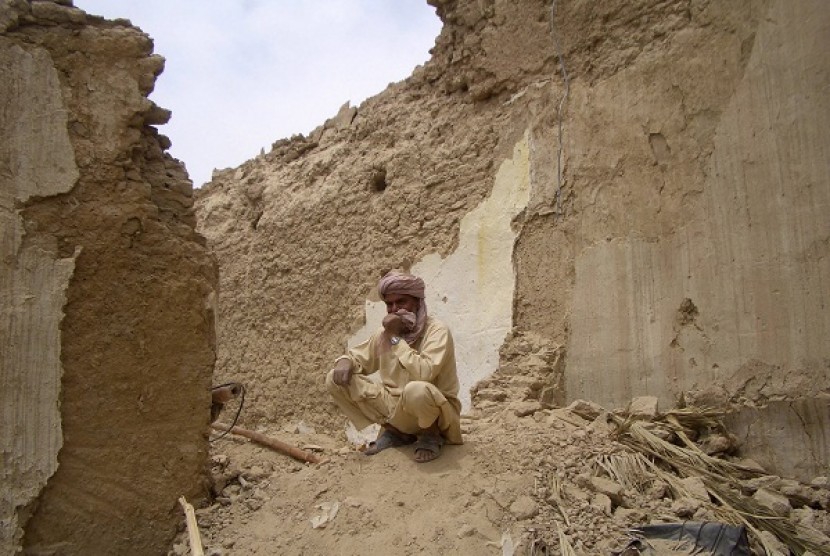 A survivor of Tuesday's earthquake sits on the rubble of his mud house after it collapsed following the quake in the town of Mashkeel, southwestern Pakistani province of Baluchistan, near the Iranian border April 17, 2013. 