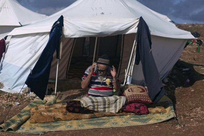 A Syrian elderly disabled man who fled from the violence in his village, prays in front of his tent at a displaced camp, in the Syrian village of Atma, near the Turkish border with Syria. Saturday, Nov. 10, 2012.   