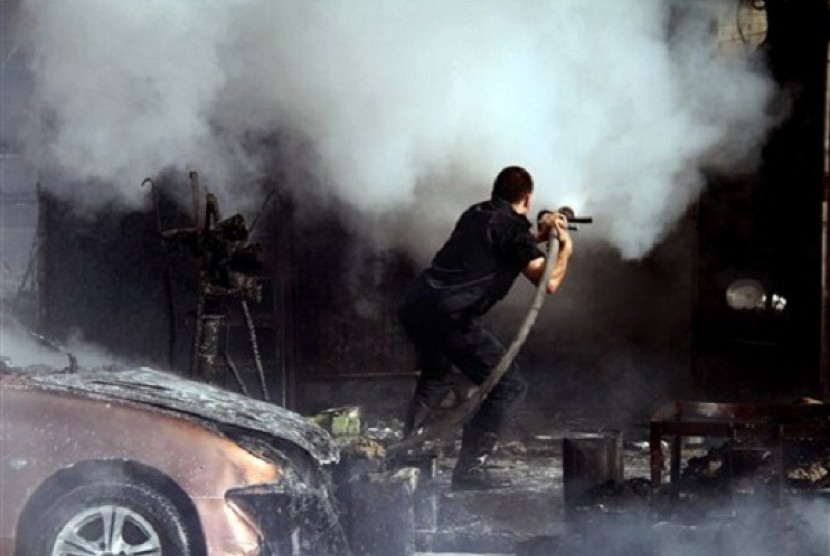 A Syrian firefighter extinguishes at the scene where two mortar rounds exploded near an orphanage, at al-Boukhtyar area, in Damascus, Syria, Wednesday March 13, 2013. 