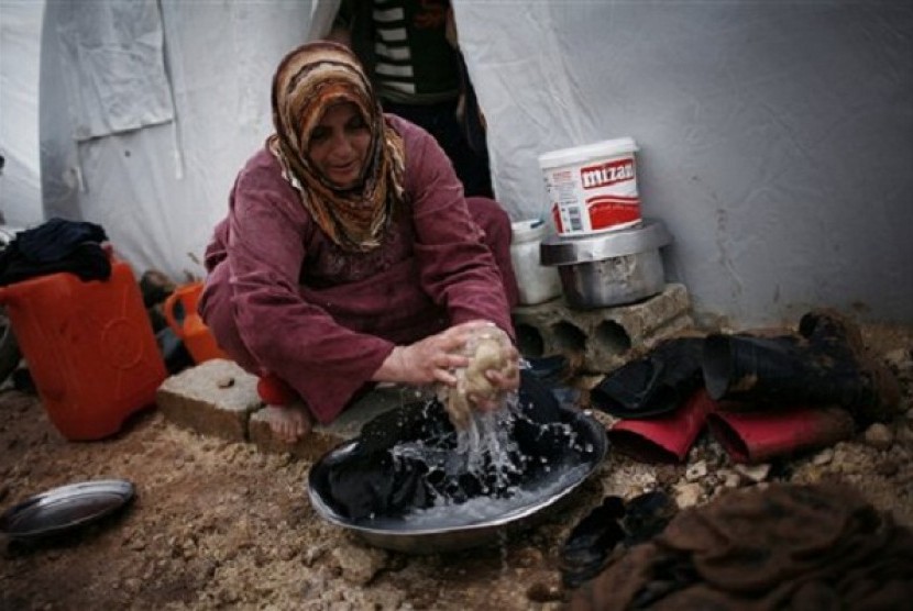 A Syrian refugee woman washes some clothes in front of her tent in a refugee camp near Azaz, north of Aleppo province, Syria. (file photo)