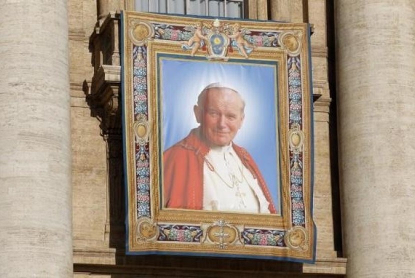 A tapestry featuring Pope John Paul II is seen in St. Peter's square at the Vatican, April 25, 2014.