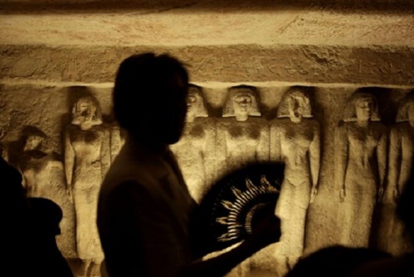 A tourist uses a hand fan, inside the tomb that belongs to Queen Meresankh III at the historical site of the Giza Pyramids, near Cairo, Egypt. (illustration)  