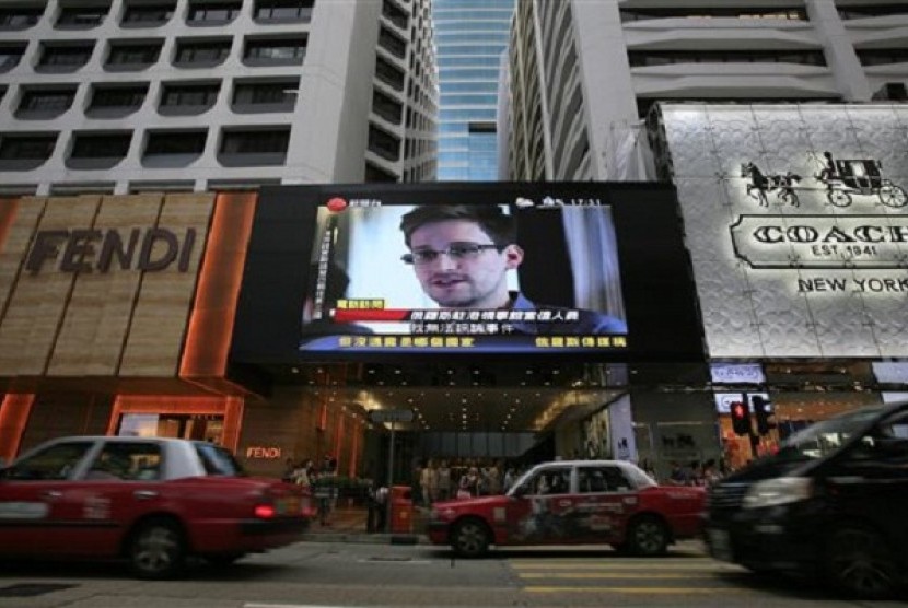 A TV screen shows a news report of Edward Snowden, a former CIA employee who leaked top-secret documents about sweeping US surveillance programs, at a shopping mall in Hong Kong Sunday, June 23, 2013. 