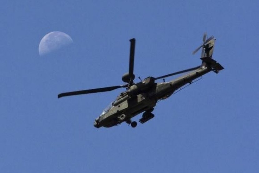 A U.S. Army Apache flies past the moon in the Zharay district of Kandahar province, southern Afghanistan June 11, 2012.