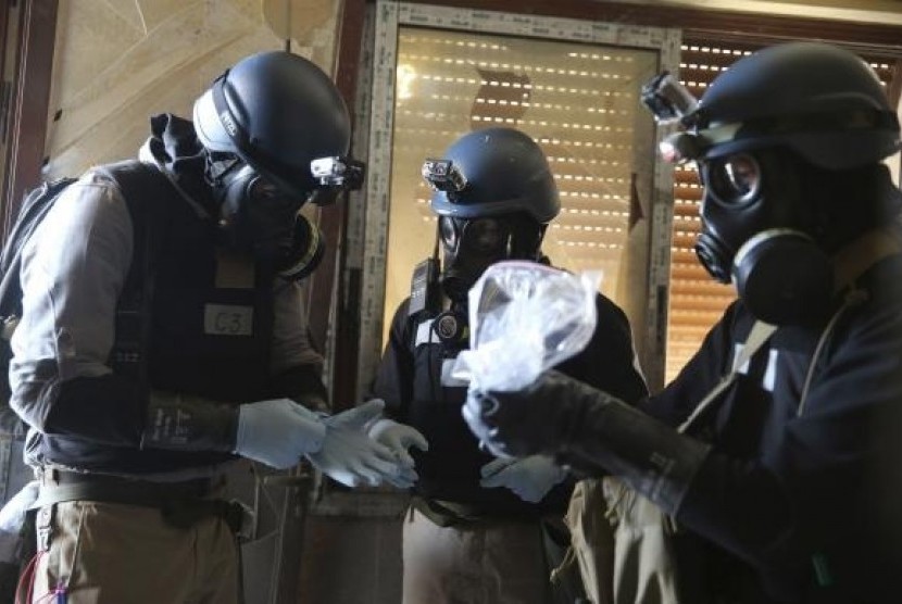 A UN chemical weapons expert, wearing a gas mask, holds a plastic bag containing samples from one of the sites of an alleged chemical weapons attack in the Ain Tarma neighbourhood of Damascus August 29, 2013.
