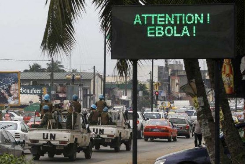 A UN convoy of soldiers passes a screen displaying a message on Ebola on a street in Abidjan August 14, 2014.