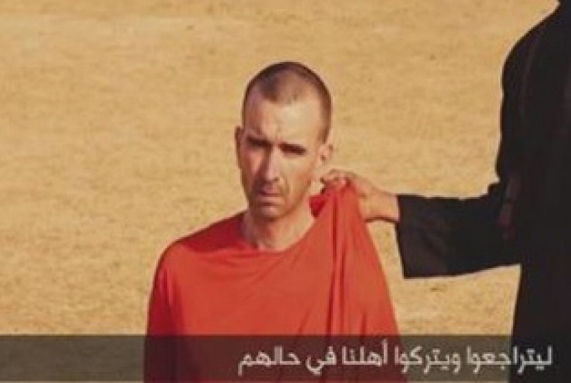 A video purportedly showing threats being made to a man Islamic State (IS) named as David Haines by a masked IS man in this still image from video released by Islamic State September 2, 2014.