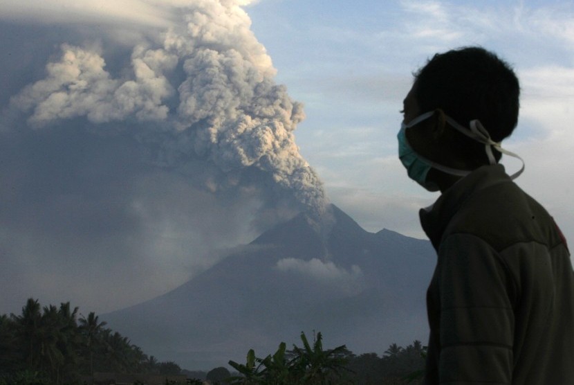 A villager watches from Jambon village in the Sleman district of Indonesia's central Java province, as Mount Merapi spews smoke and ash, in November 2010. (photo file)