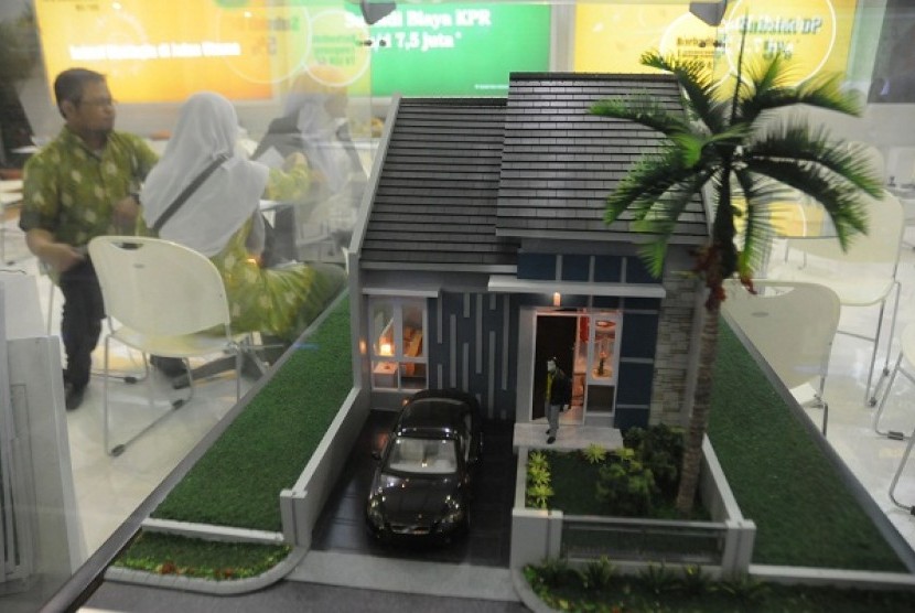A visitor watches closely a miniature of housing in an exhibition in Jakarta. (file photo)