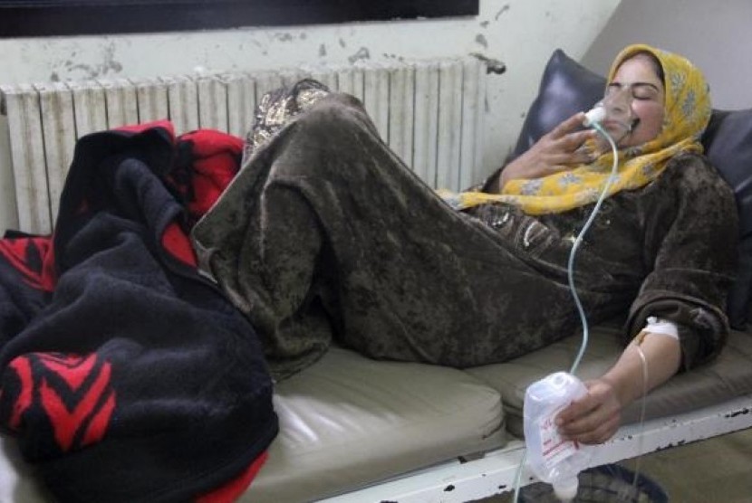 A woman, affected by what activists say was a gas attack, breathes through an oxygen mask inside a field hospital in Kfar Zeita village in the central province of Hama April 12, 2014.