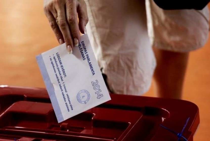 A woman casts her vote during European Parliament elections in Riga May 24, 2014.