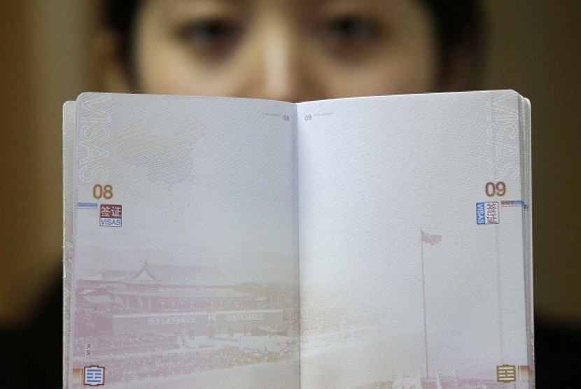  A woman holds a Chinese passport, displaying a Chinese map which includes an area in the South China Sea inside a line of dashes representing maritime territory claimed by China (left, top) and a picture of Beijing's Tiananmen Square (bottom), at an office in Wuhan airport, Hubei province, November 23, 2012. 