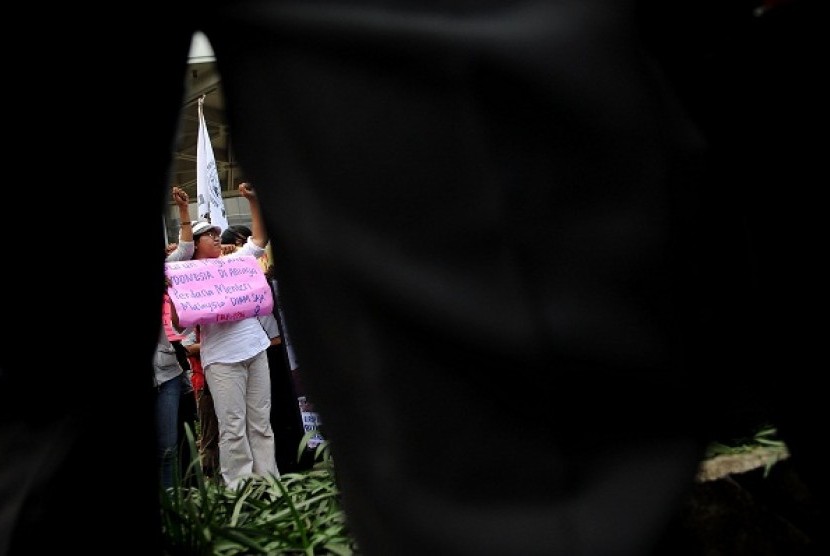 A woman holds a poster during a protest in Jakarta on violence against Indonesian female workers abroad. (file photo)