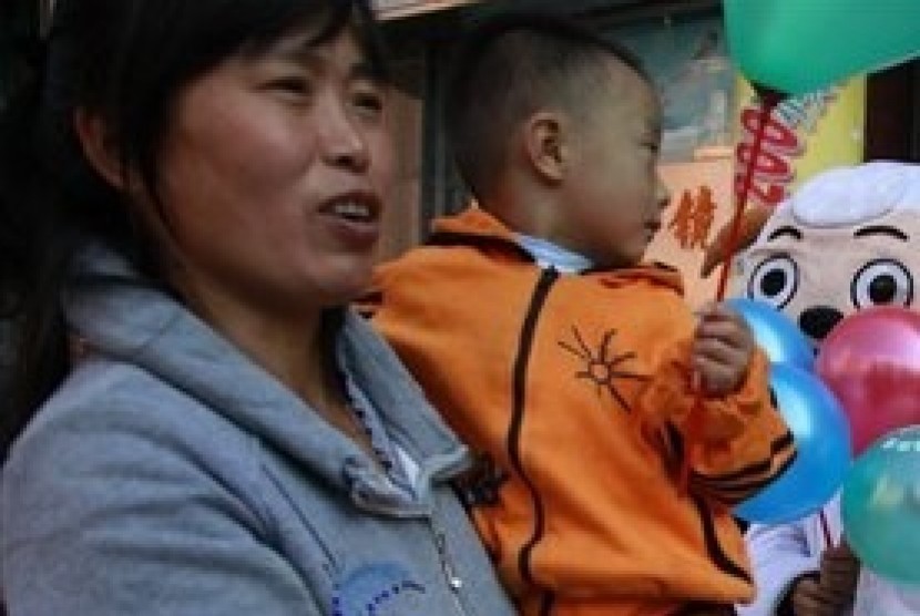 A woman holds her child on a street in Beijing, China. (File photo)